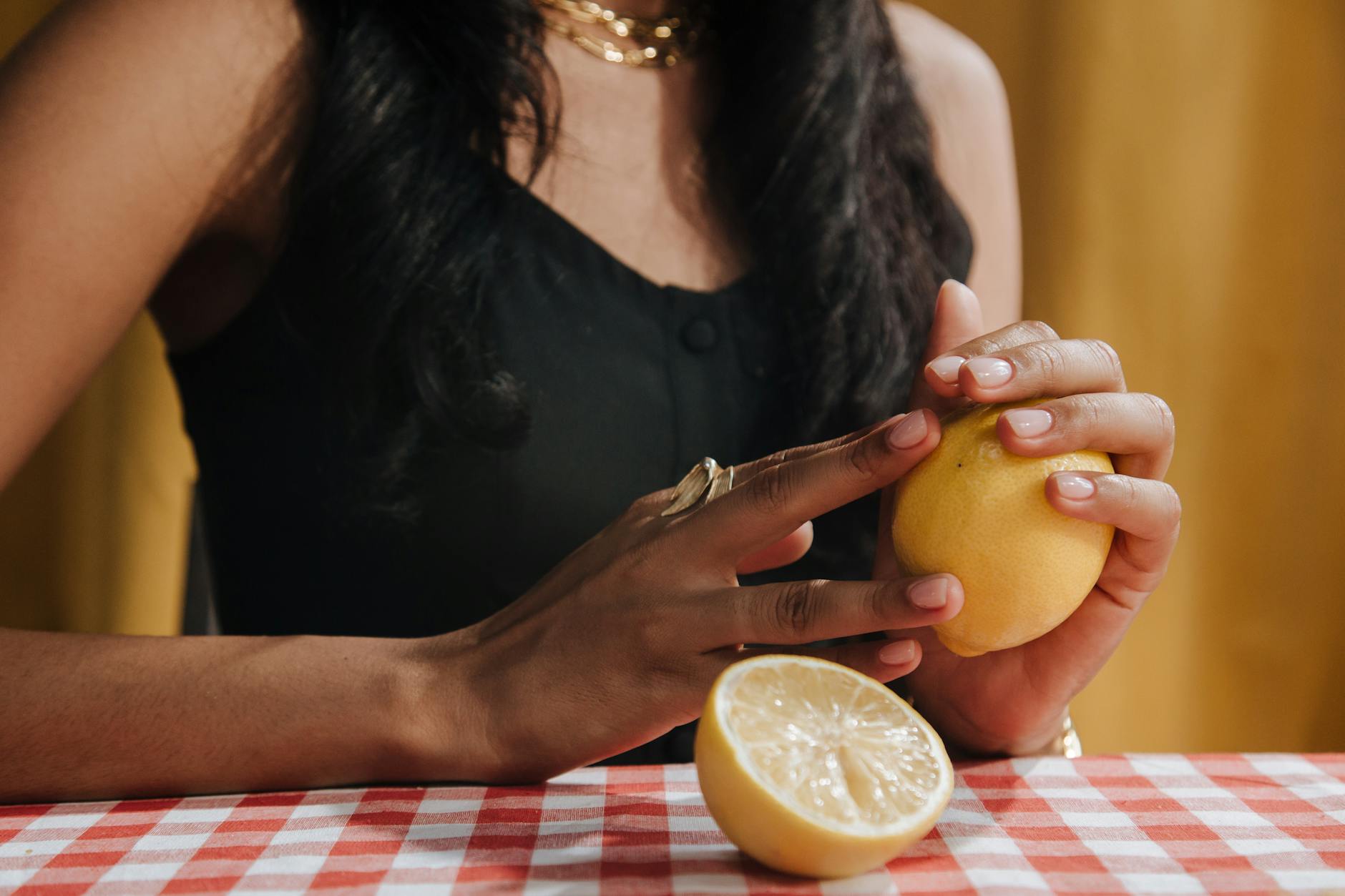 A hand holding a fresh lemon, symbolizing natural sensation and clitoral rejuvenation