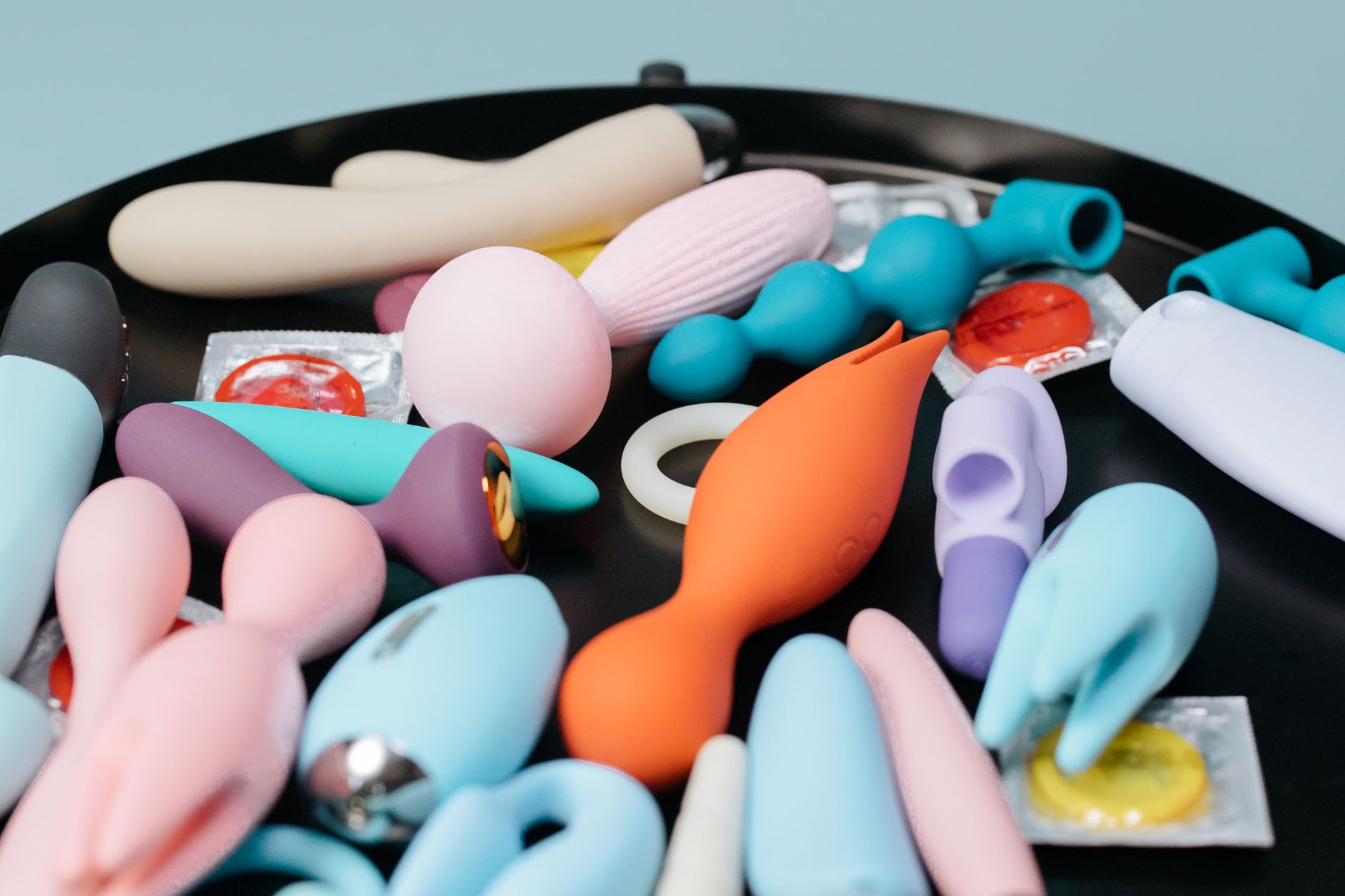 Hand holding a fresh lemon on a soft pink background